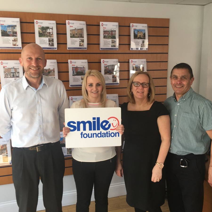 Marlborough Property Team holding Smile Foundation sign