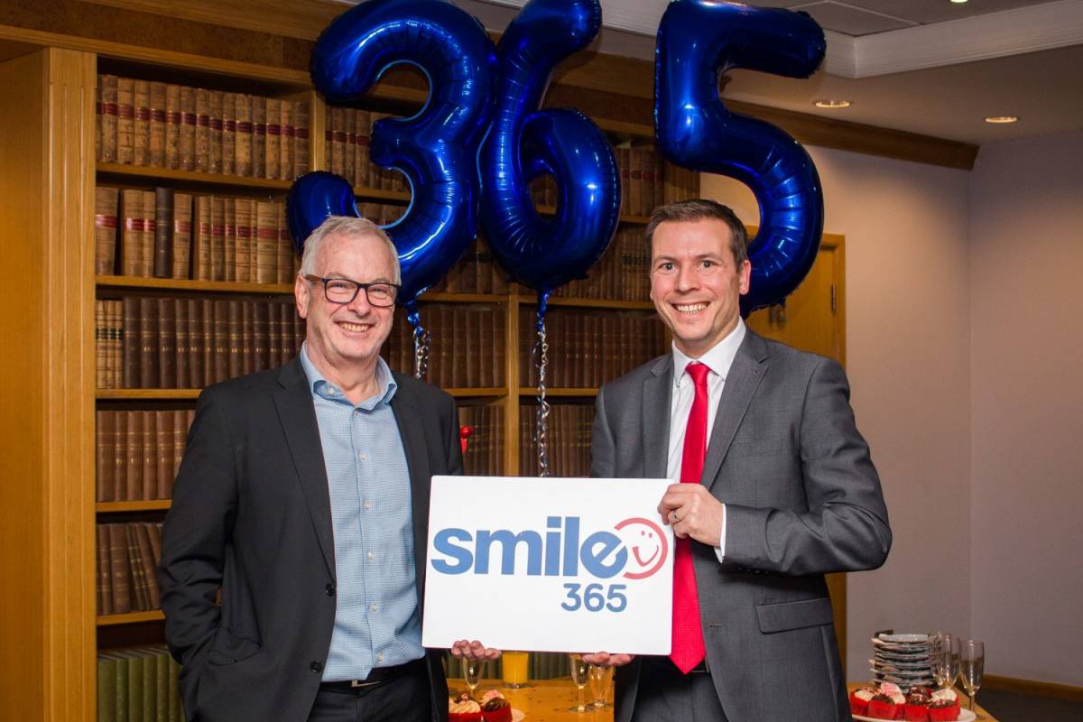 Mark Sharpley and Steve Bramall (Smailes Goldie) holding Smile365 sign with balloons in the background