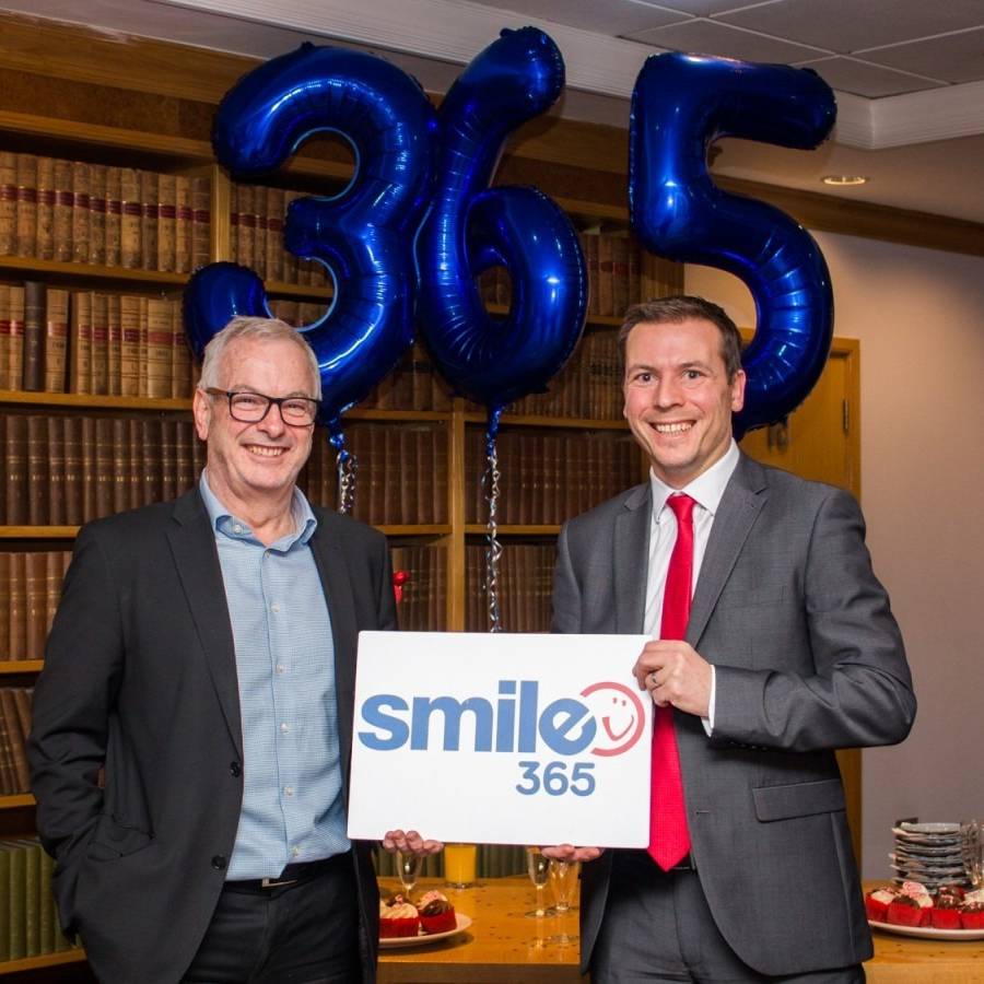 Mark Sharpley and Steve Bramall (Smailes Goldie) holding Smile365 sign with balloons in the background